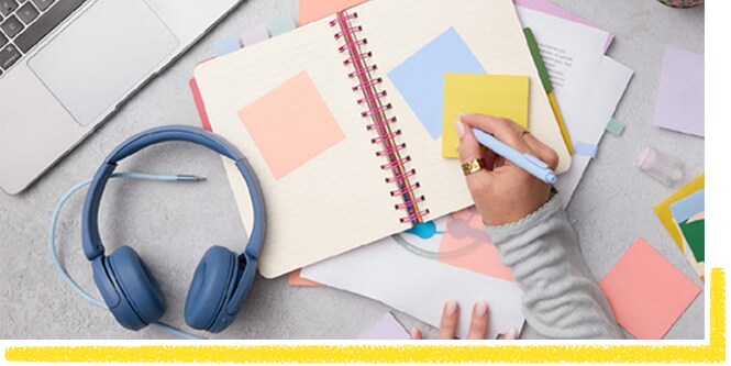 Student making notes on a yellow Post-it® Note
